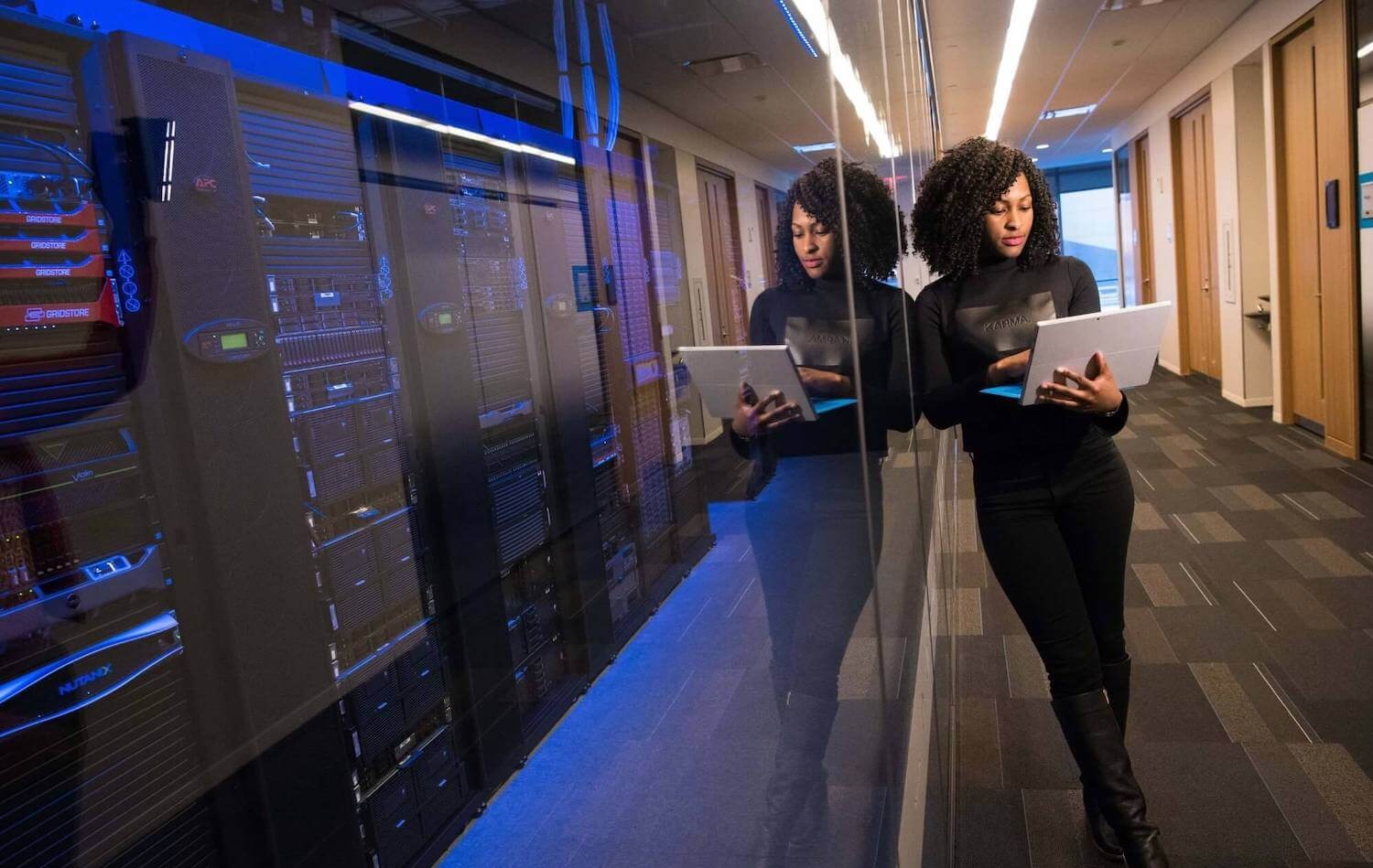 woman standing next to servers with laptop
