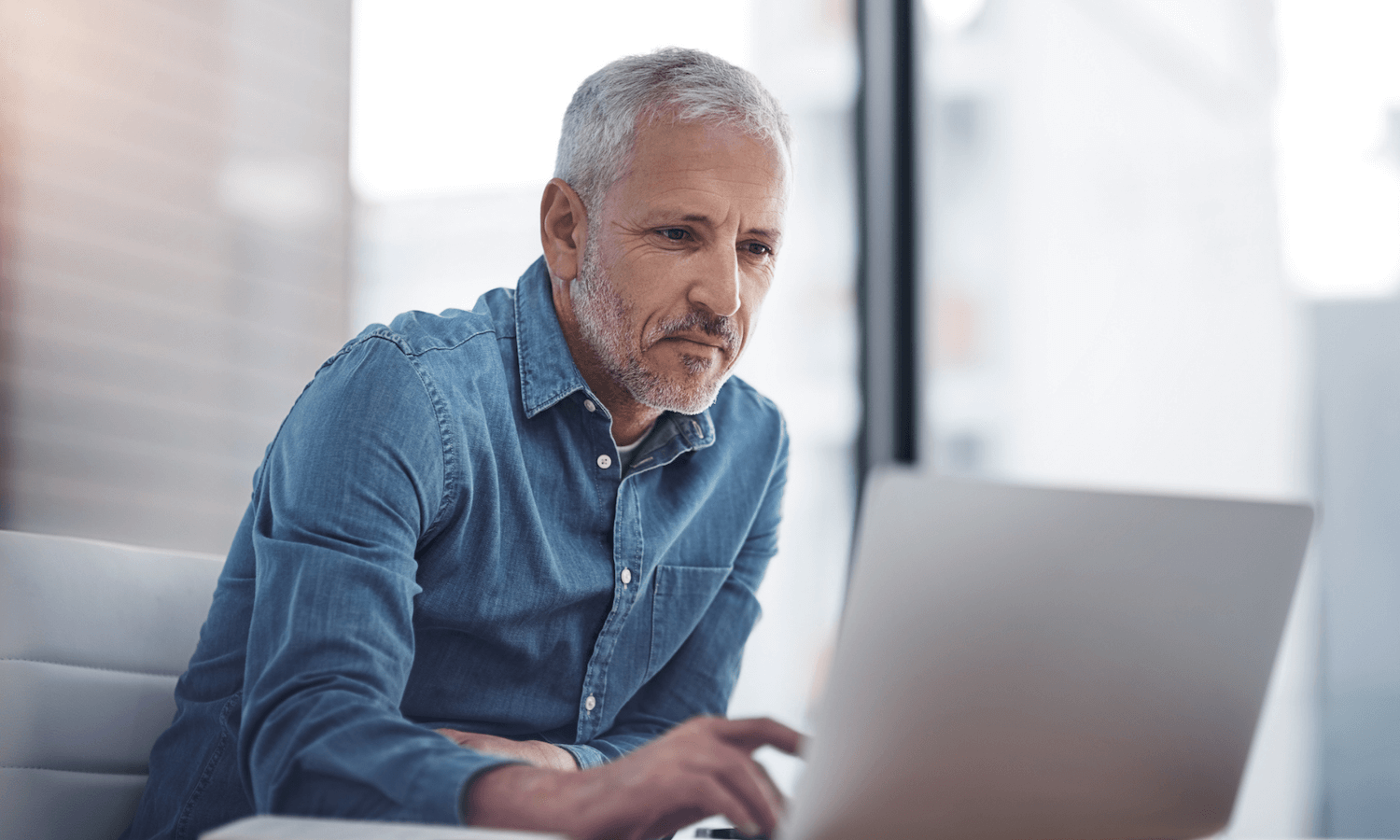 Change leader sitting in office at laptop