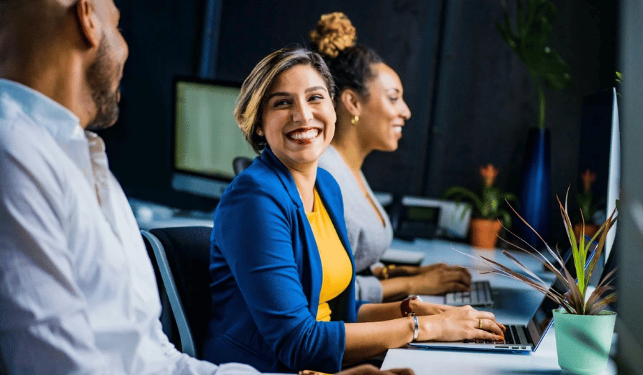 Customer service agent smiling in office with colleagues (1)