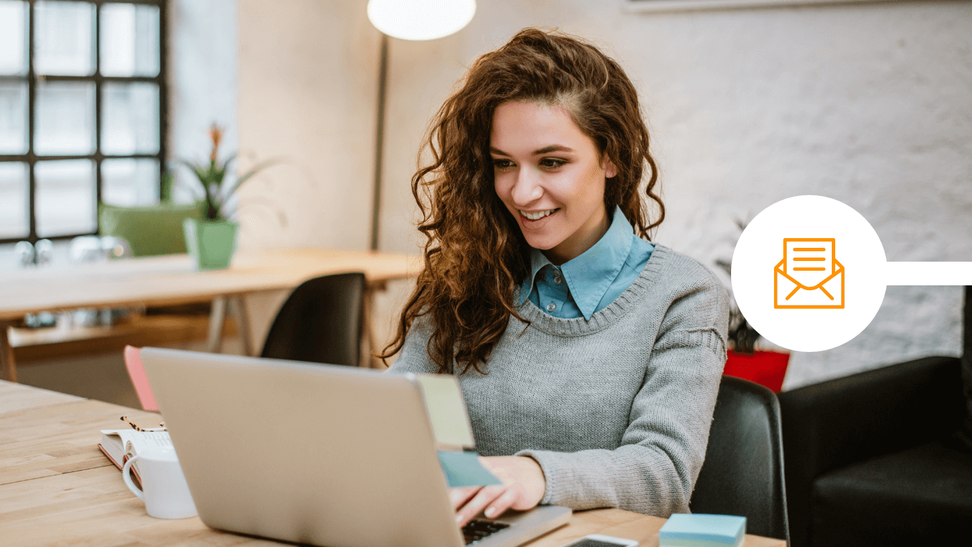 Female professional smiling and looking at laptop on modern office desk