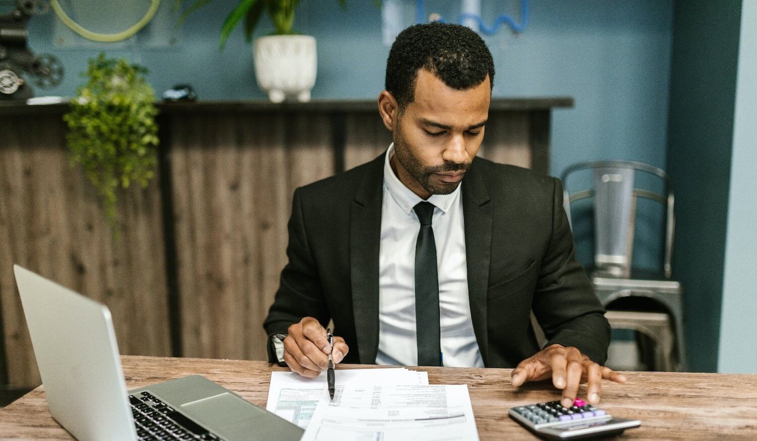 Financial adviser using calculator at desk