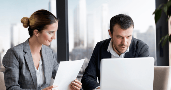 Financial advisers looking at wealth planning dashboard on laptop