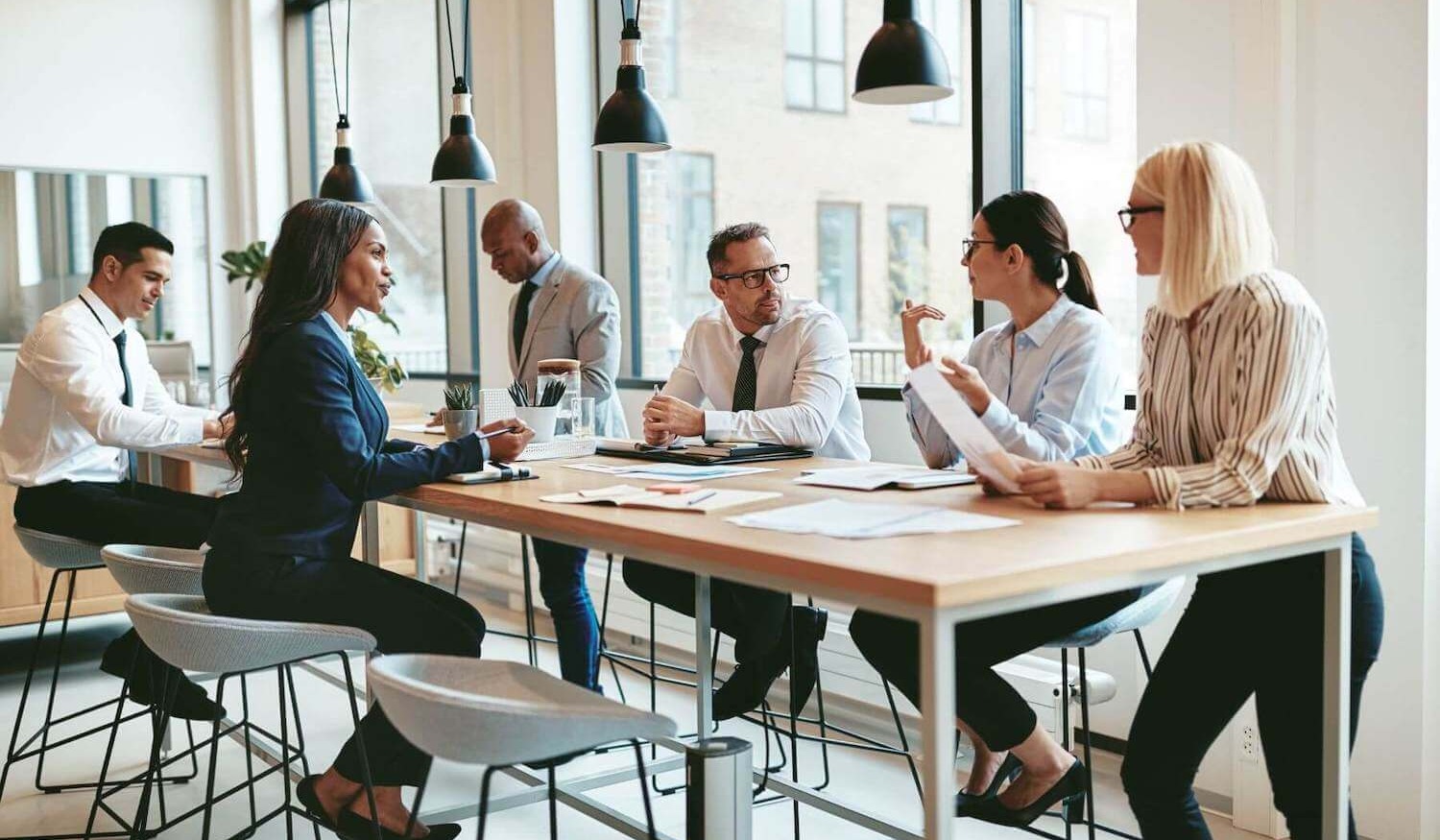 Financial advisers sitting around table in modern office