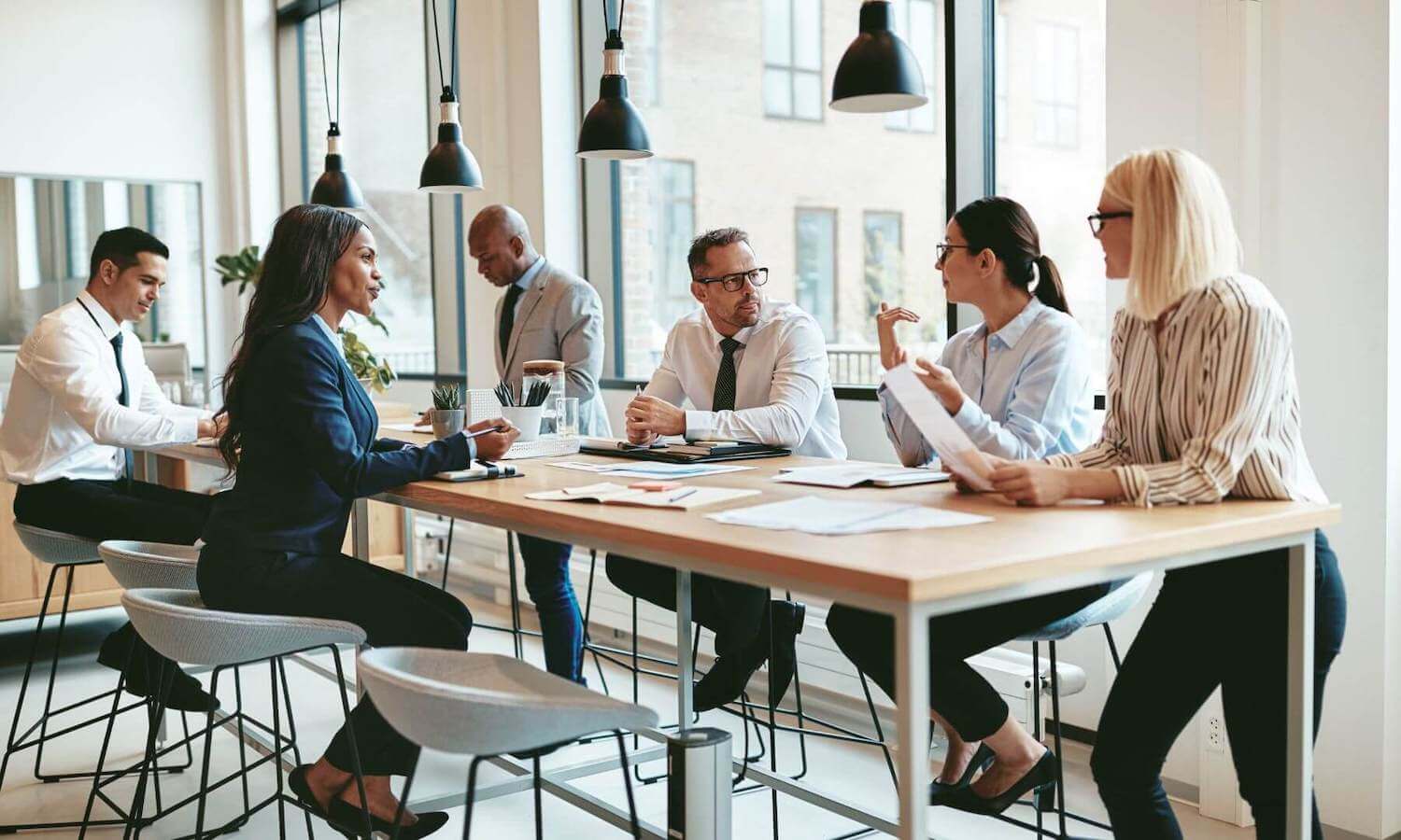 Financial advisers sitting around table in modern office