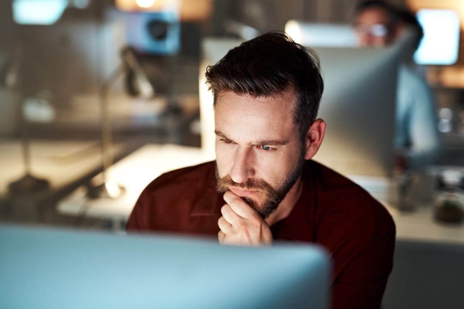 IT Team Member Looking At Computer In Office Using Mailock Automated Email Encryption