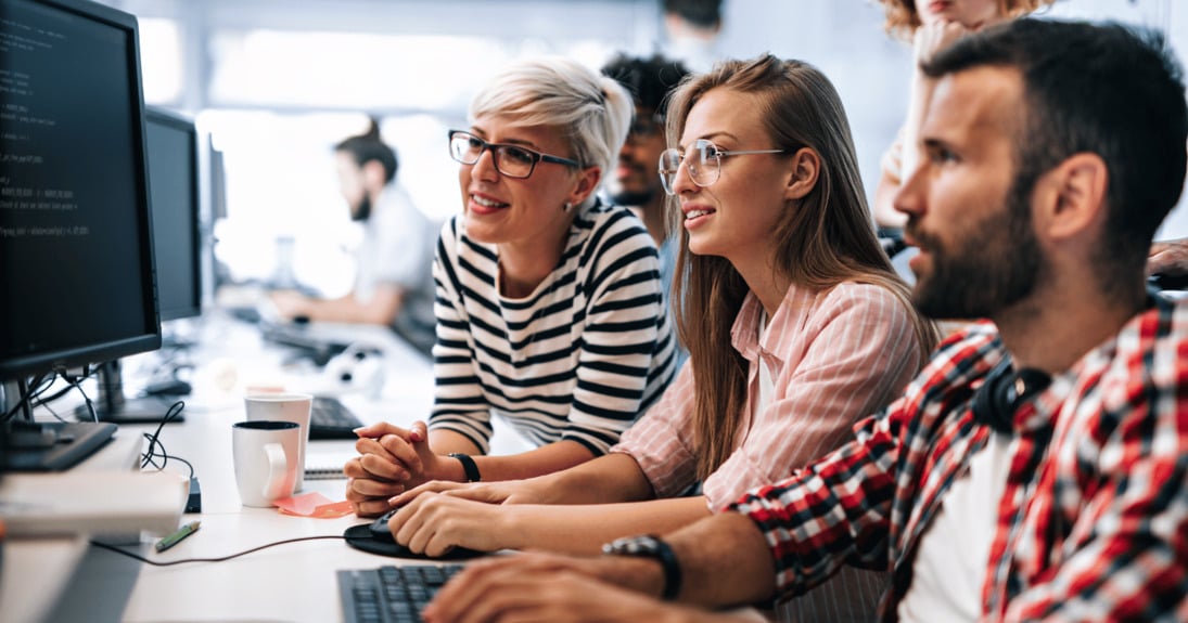 IT team in office looking at computer together