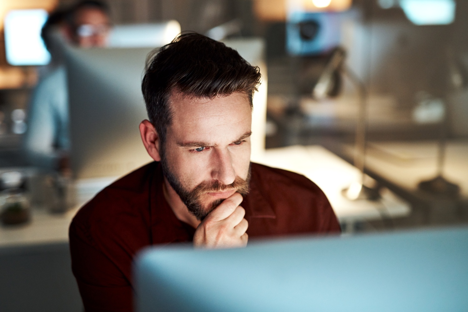 IT team member looking at computer screen intently reviewing email encryption software