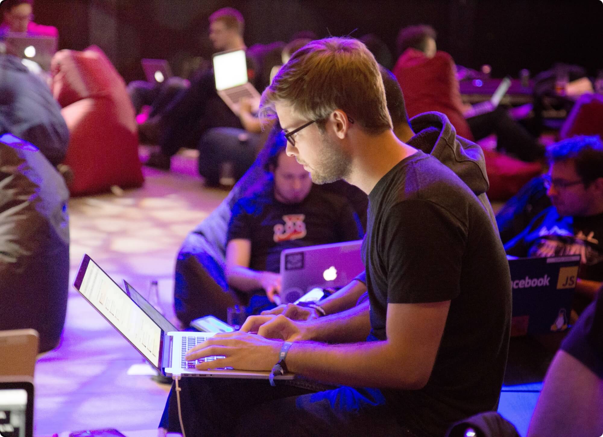 Man sending email to the wrong person on laptop at conference while busy