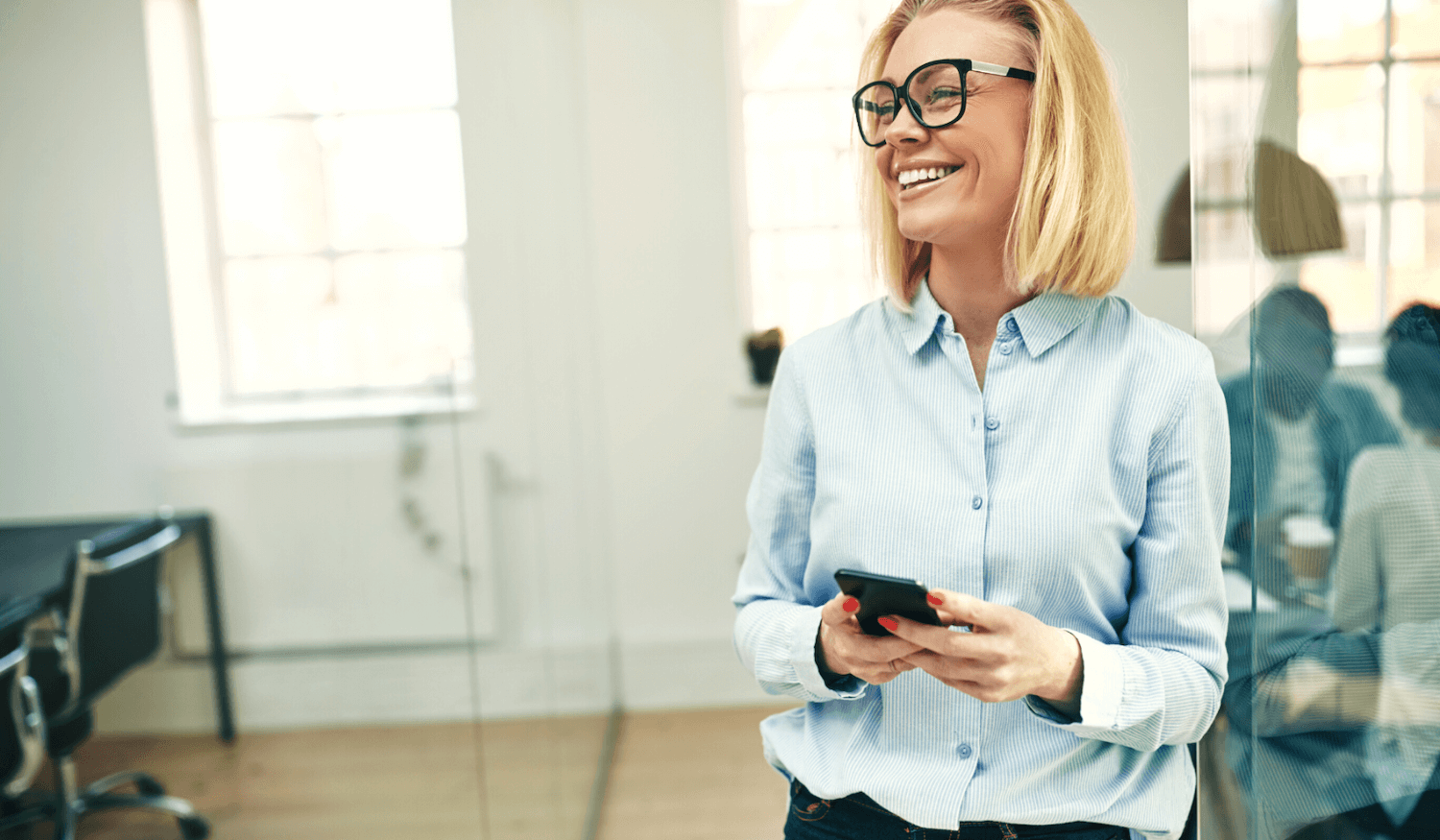 Woman smiling in office with phone