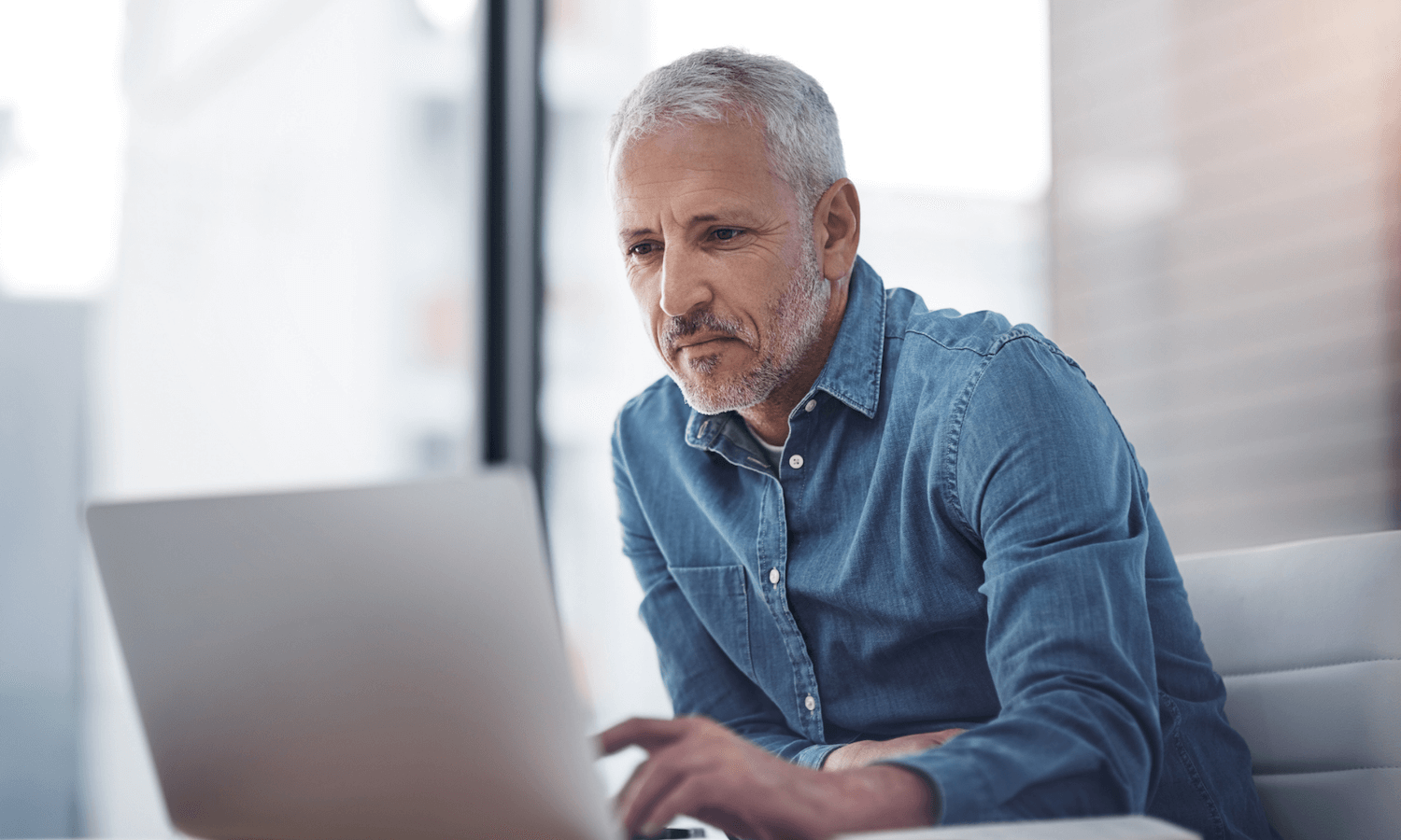 Man looking at laptop in corporate office