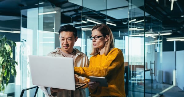 Male and female colleagues assessing problem on laptop
