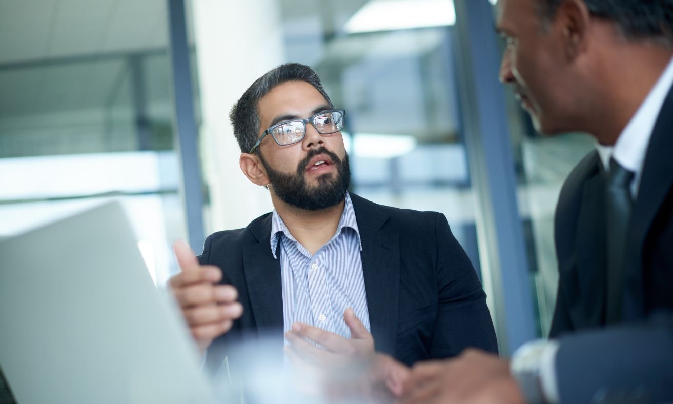 Male colleagues discussing engagement metrics in corporate setting