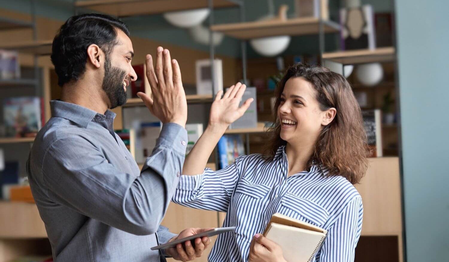 Man and woman colleagues slapping each others hands