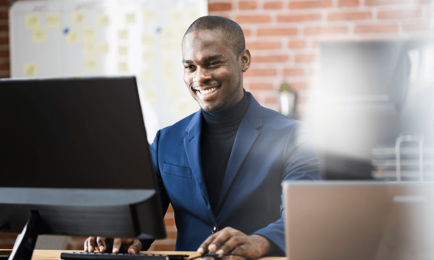 Man encrypting emails on desktop computer and smiling