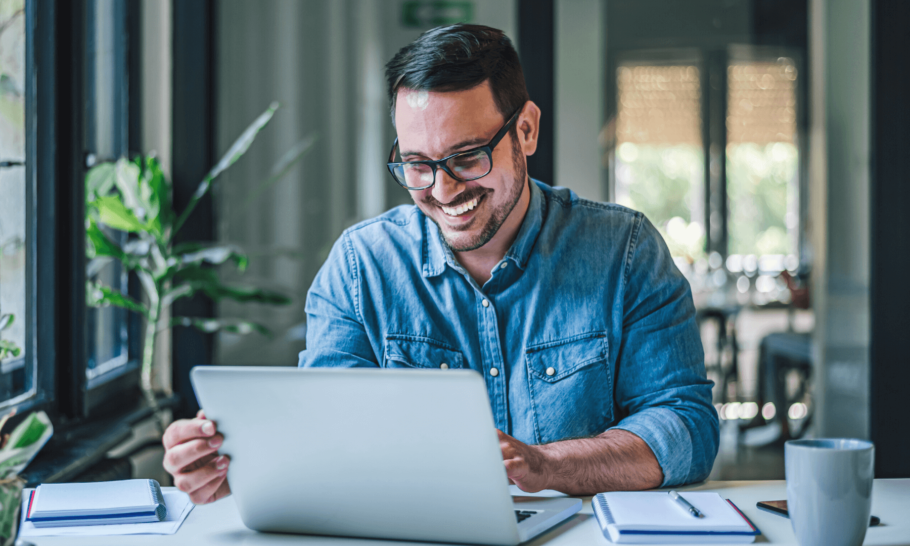 Young male professional using laptop to send secure emails in office