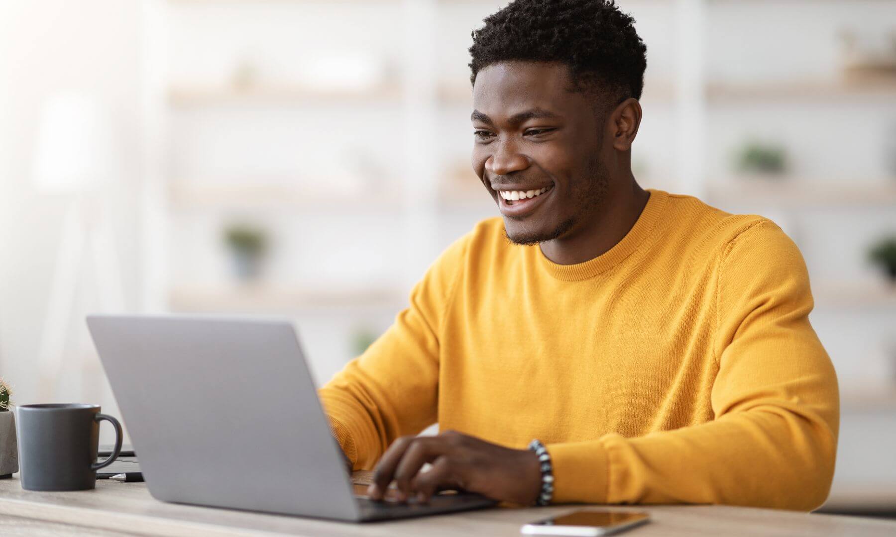 Man in office securing email and smiling with a coffee cup (1)