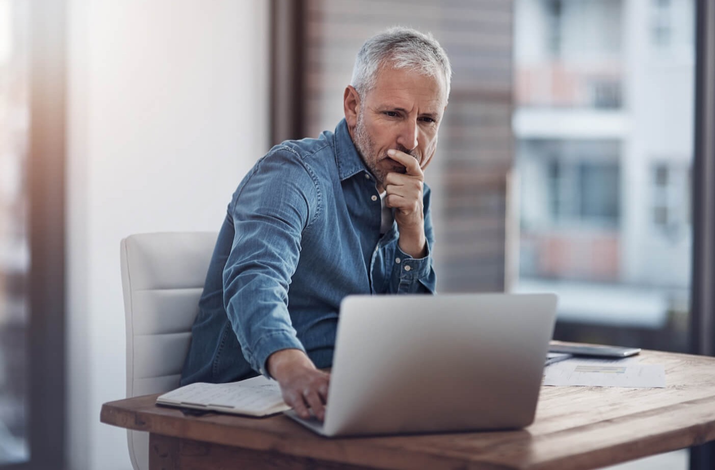 Male professional looking at laptop with secure email platform on