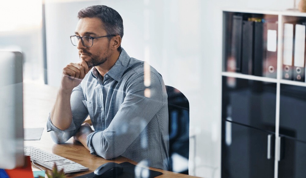 Man looking at his desktop screen in an office