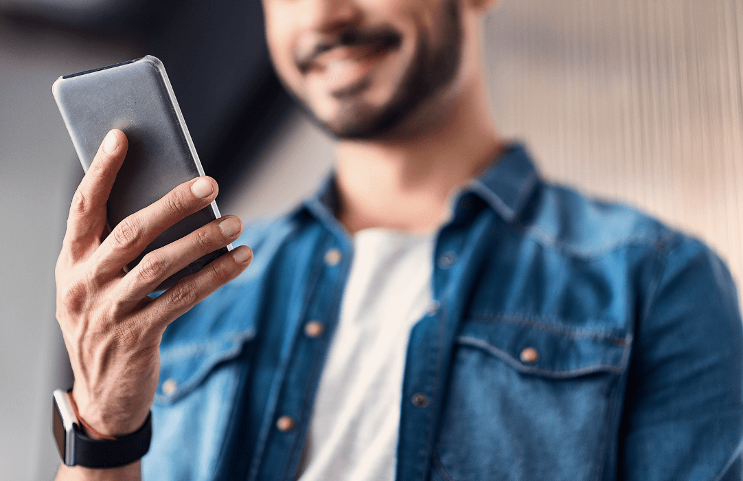 Man looking at smartphon and smiling