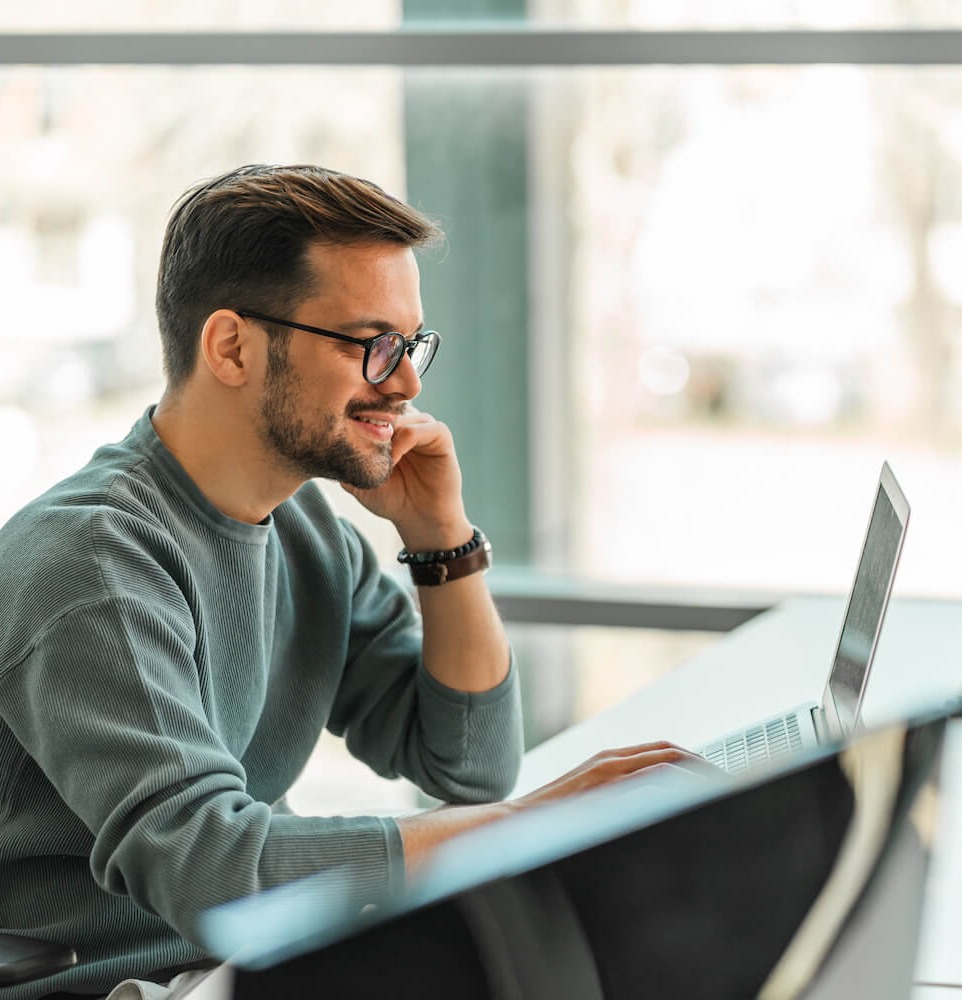 male IT professional on smartphone and laptop using automated secure email