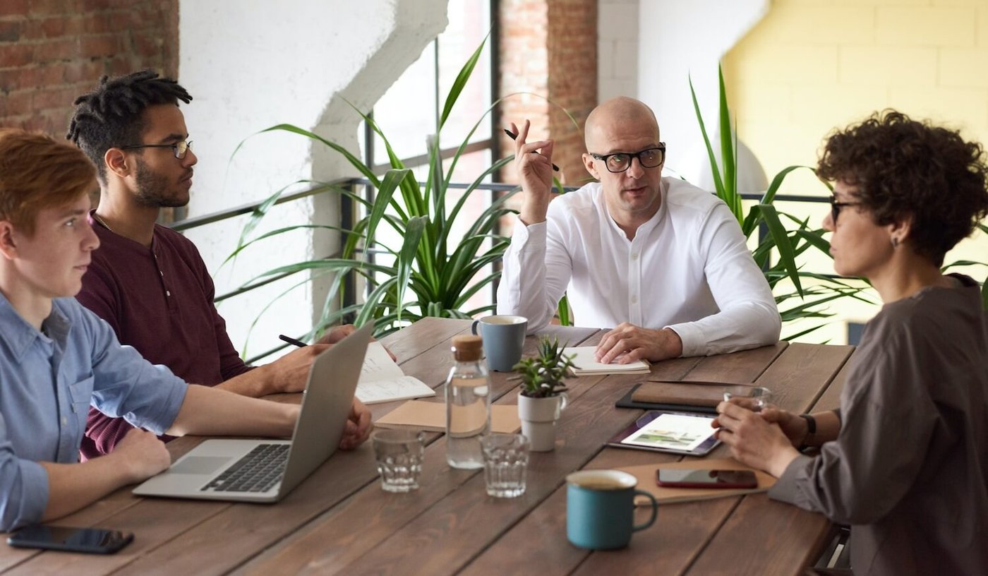 team sitting around table in meeting