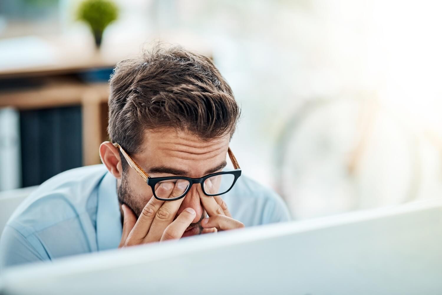 Man with face in hands after sending email to the wrong person