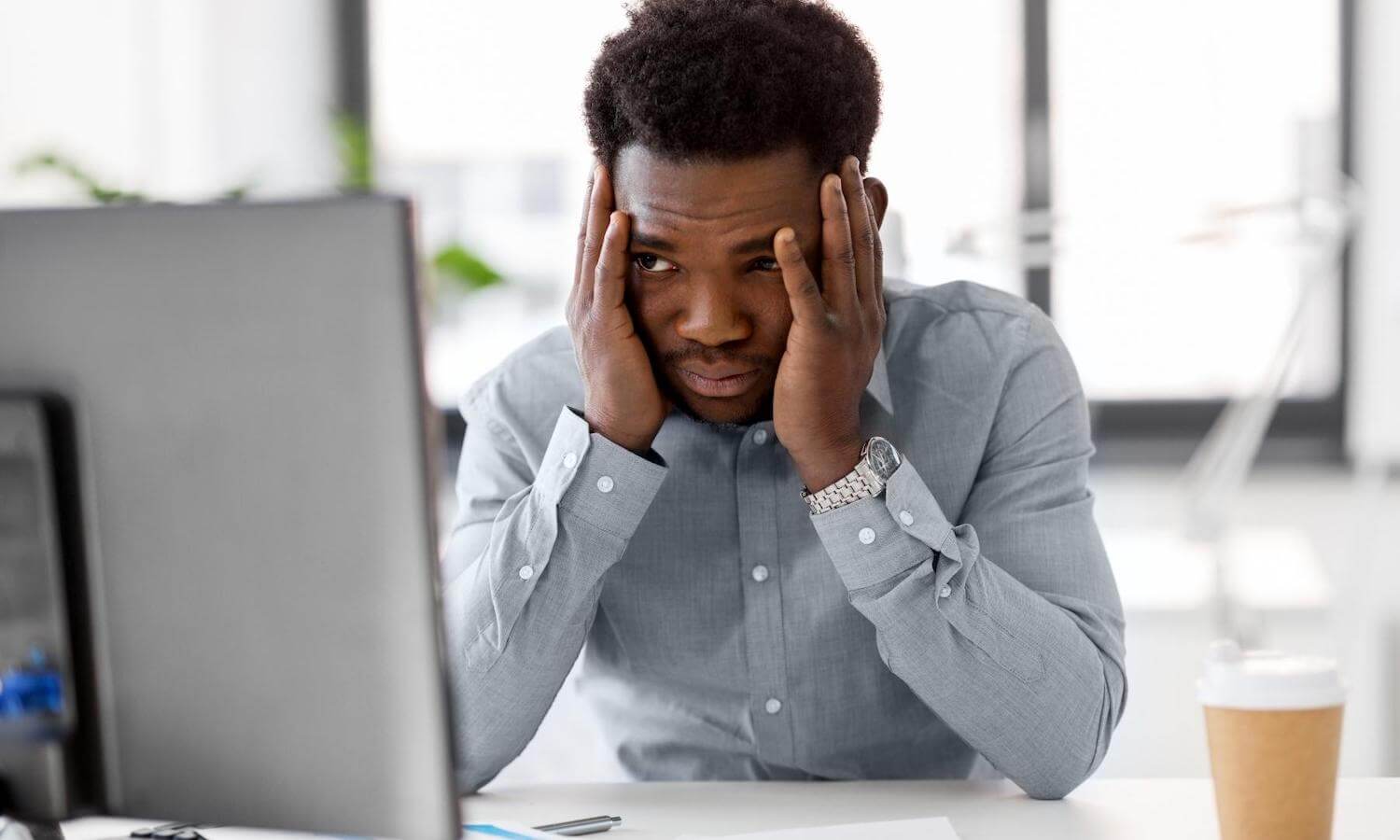 Man with hands on face stressed about human error