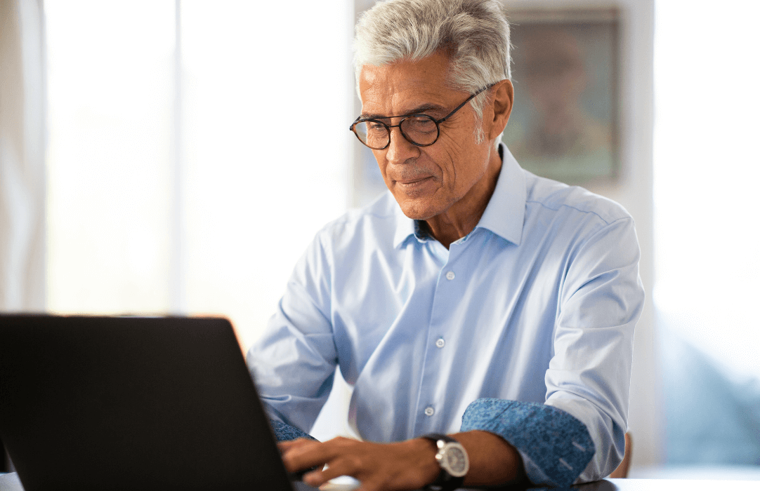 Older man securing his emails using a laptop