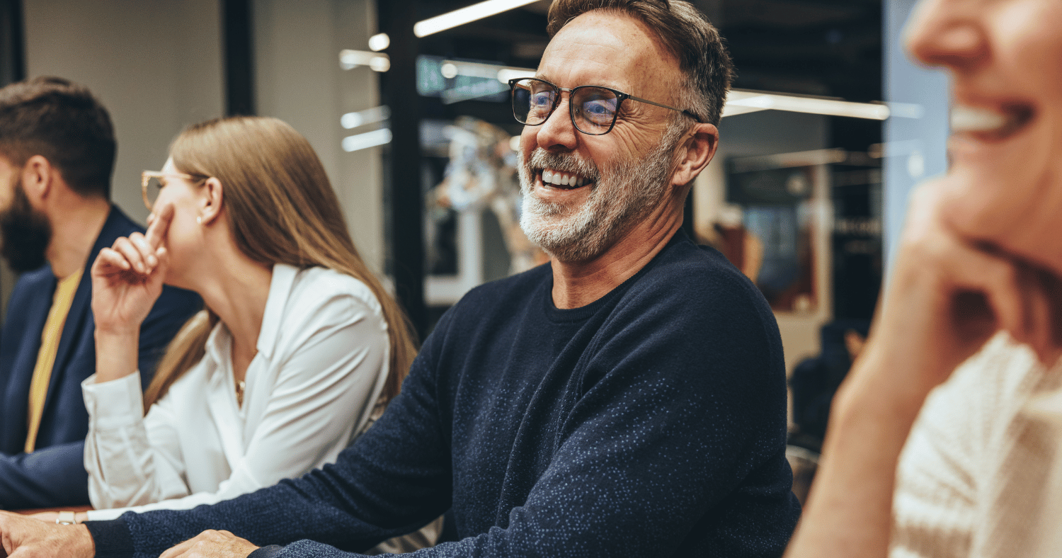 CEO laughing at board room table in modern office