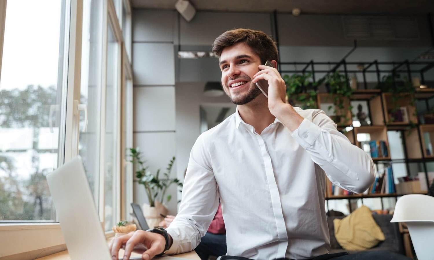 A professional man on phone and laptop at the same time in his office