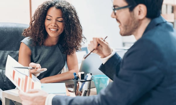Woman and man in office discussing professional responsibilities and results