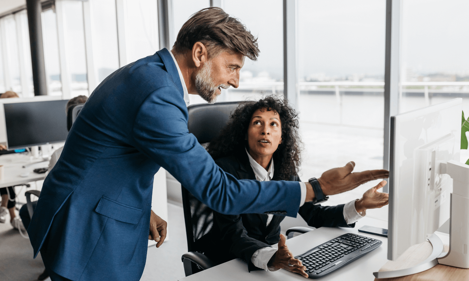 Professionals in office having a heated discussion at desk