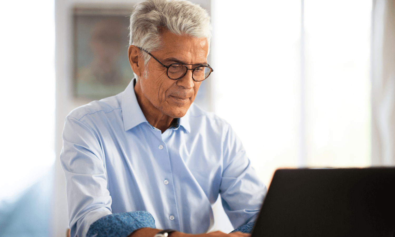 Senior male securing emails on laptop