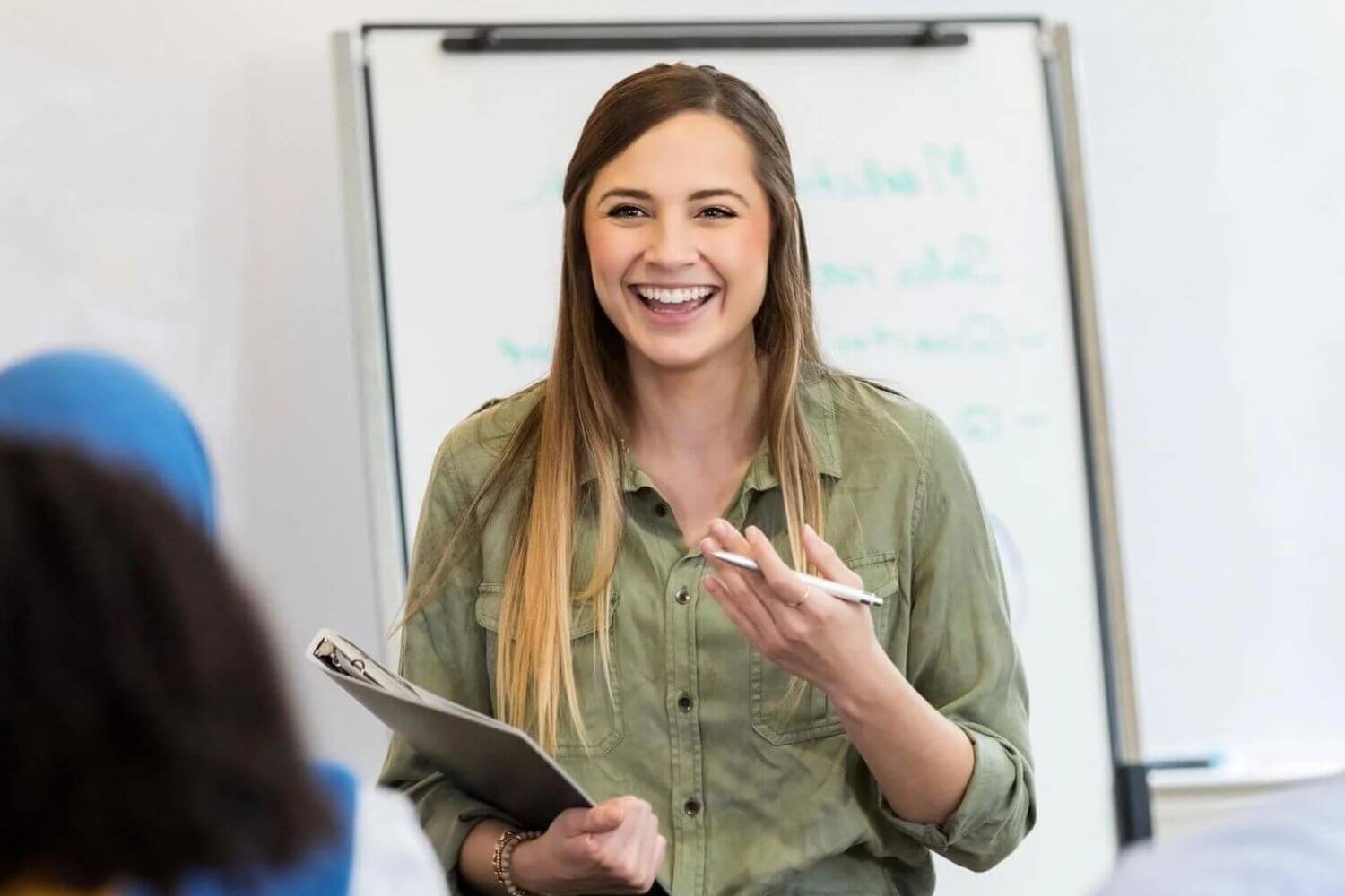 Trainer at office training with clipboard smiling