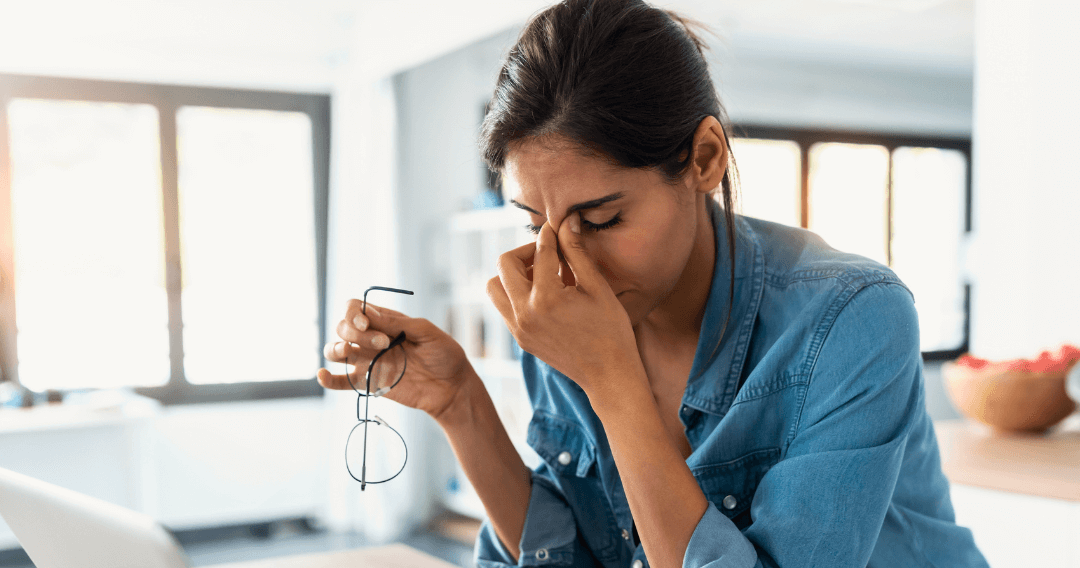 Woman holding head in front of laptop stressed with digital fatigue coloured (1)-1-1-2