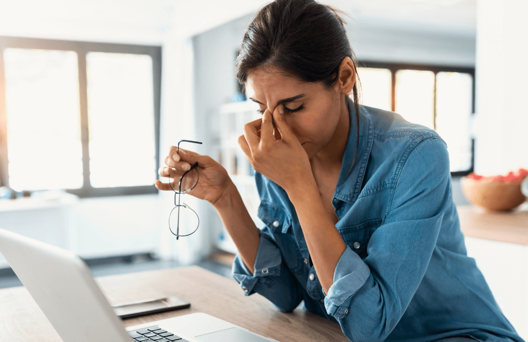 Woman holding head in front of laptop stressed with digital fatigue coloured (1)-1-1