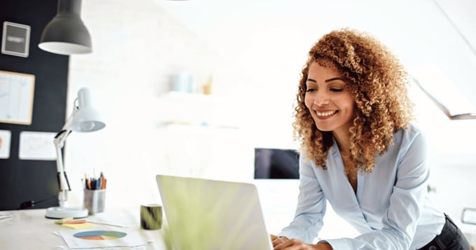 Woman receiving email in kitchen with laptop