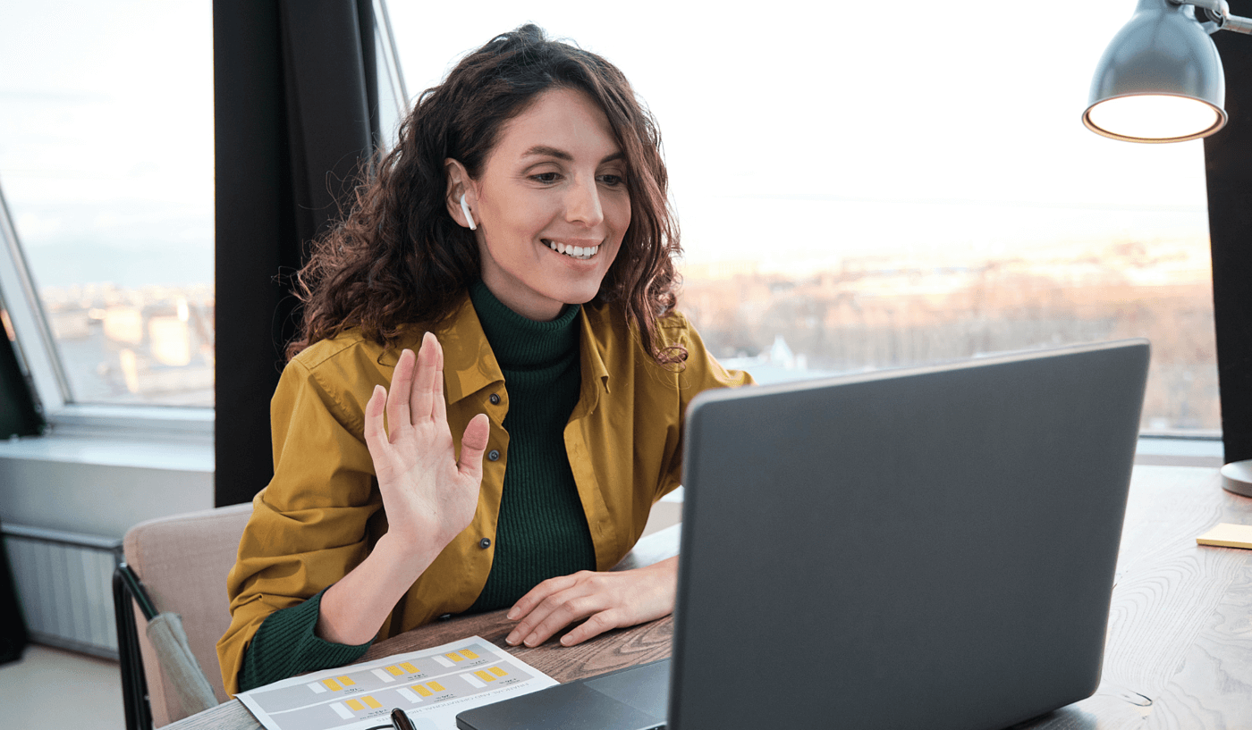 Woman speaking on Teams call with colleague using laptop in office