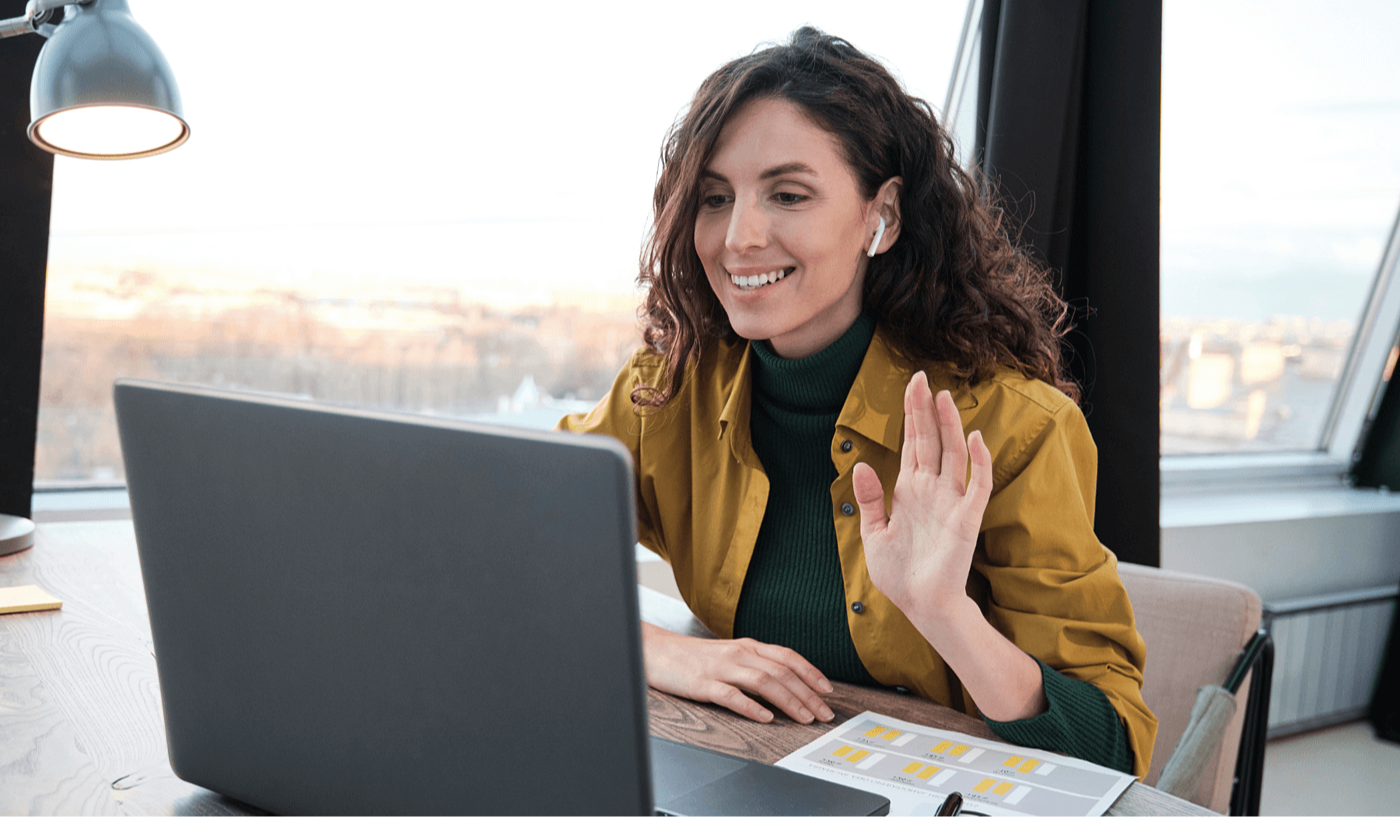 Woman speaking on Teams call with colleague using laptop in office