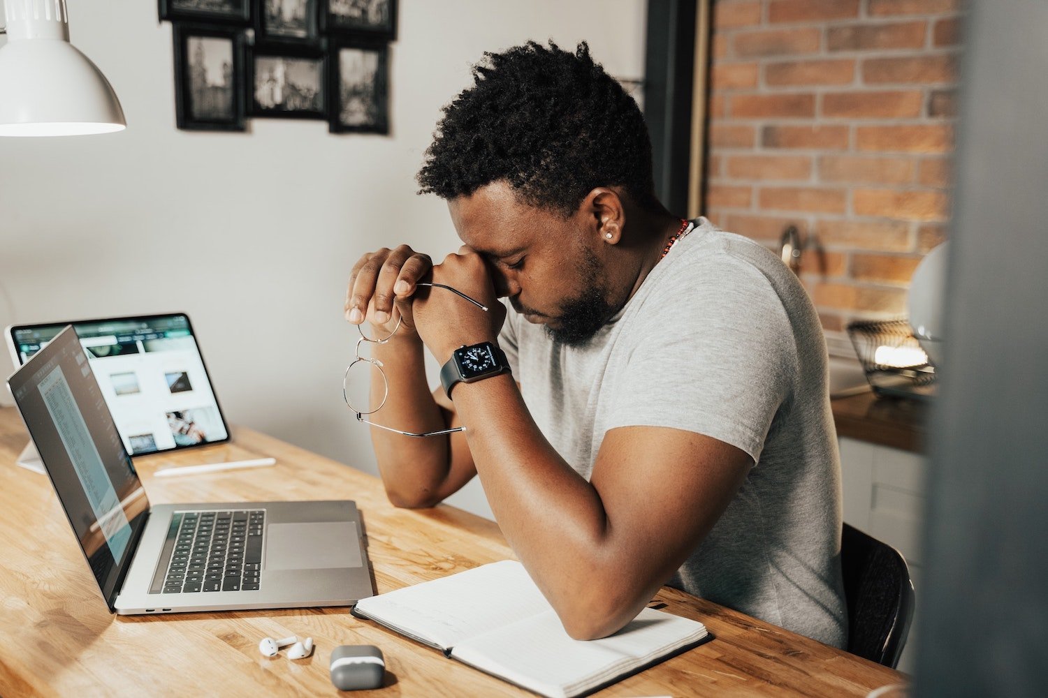 Working from home with head in hands in front of laptop