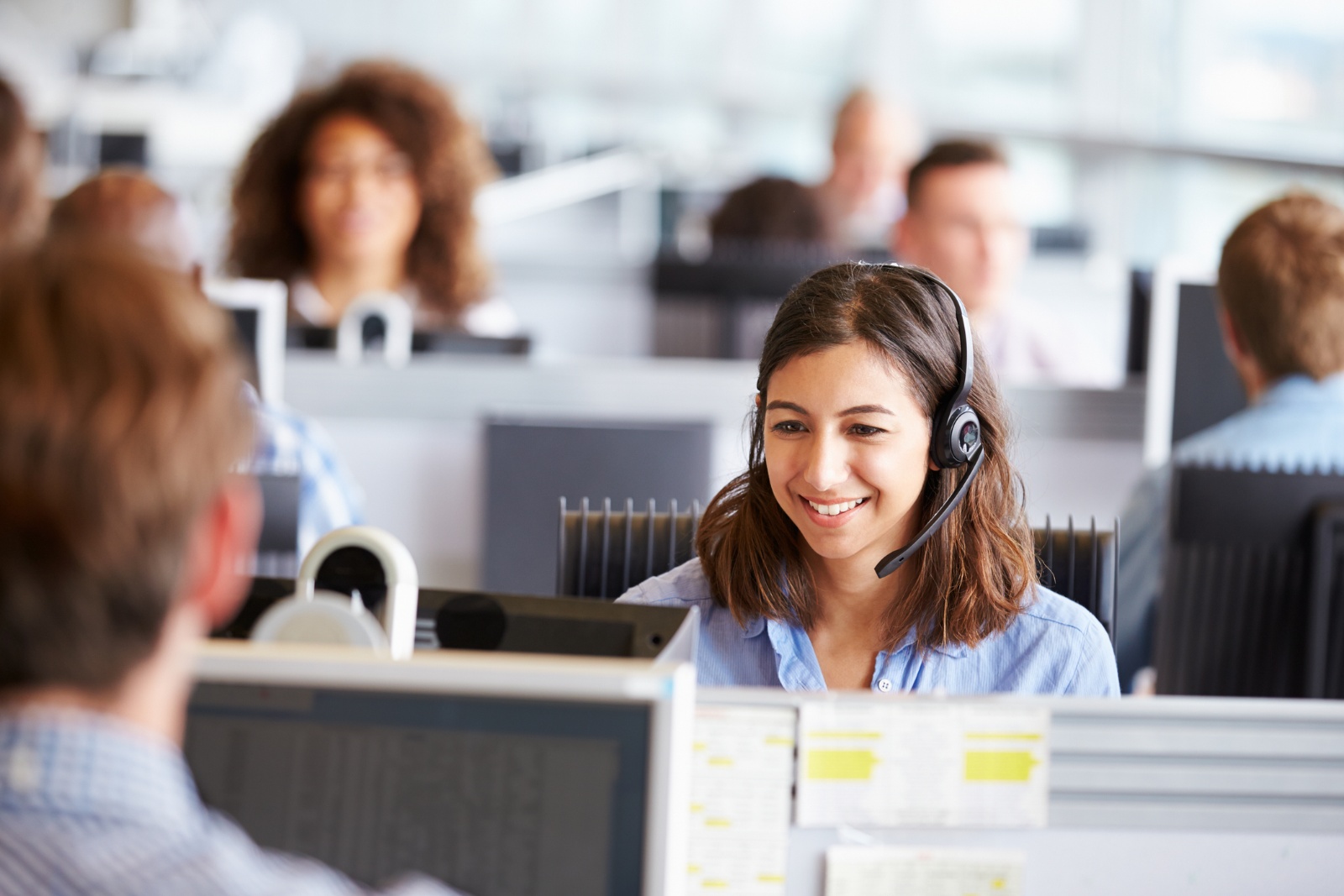 A customer service representative smiling on a call with a client