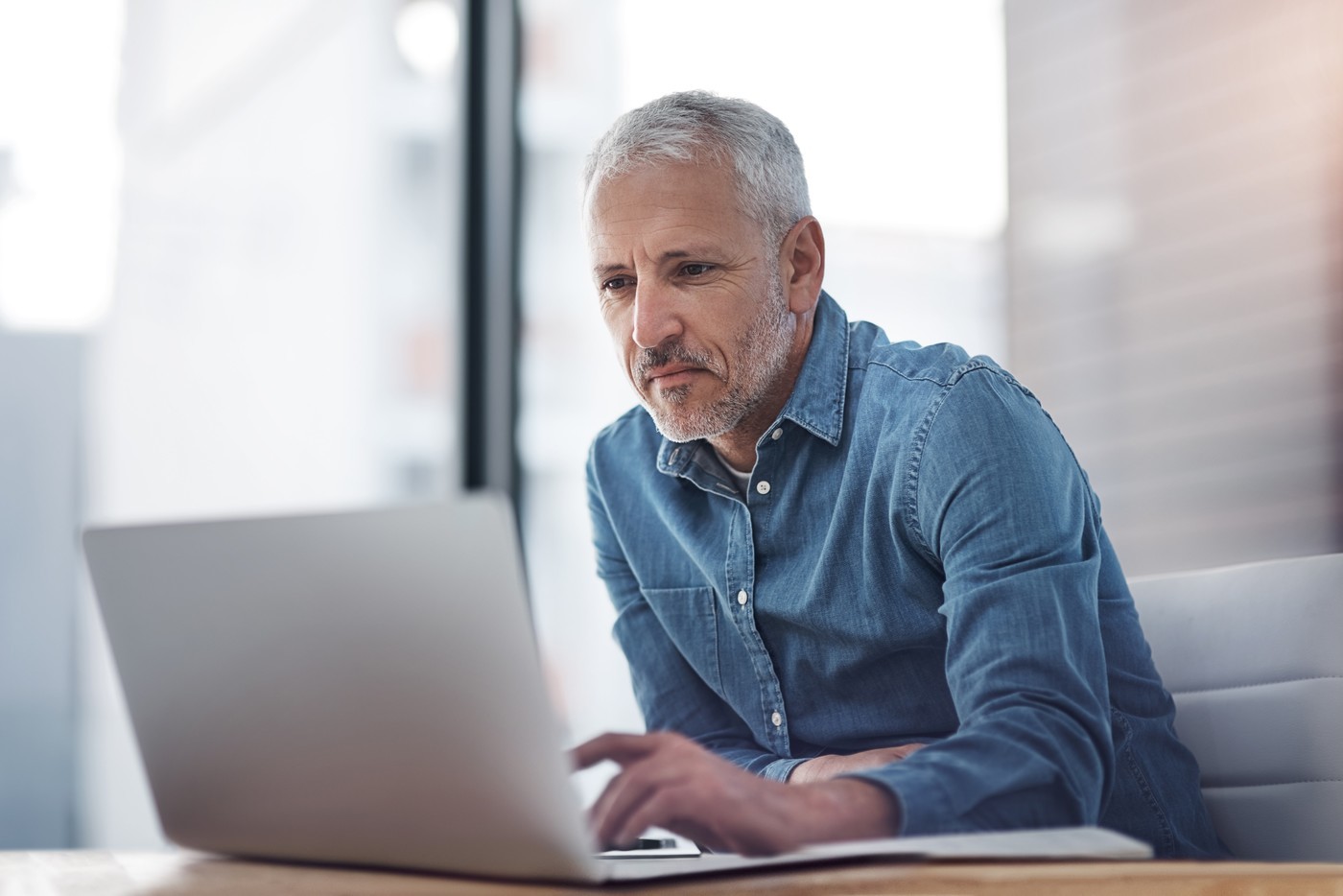 Senior male professional using laptop in office