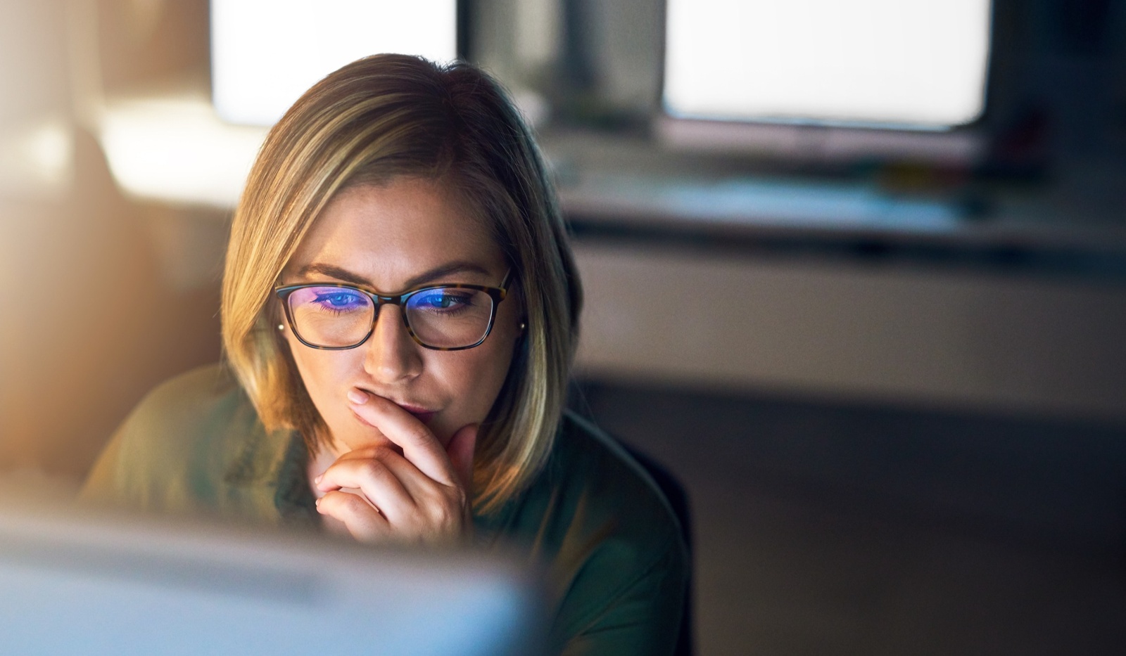 Woman looking at email security system in dark office