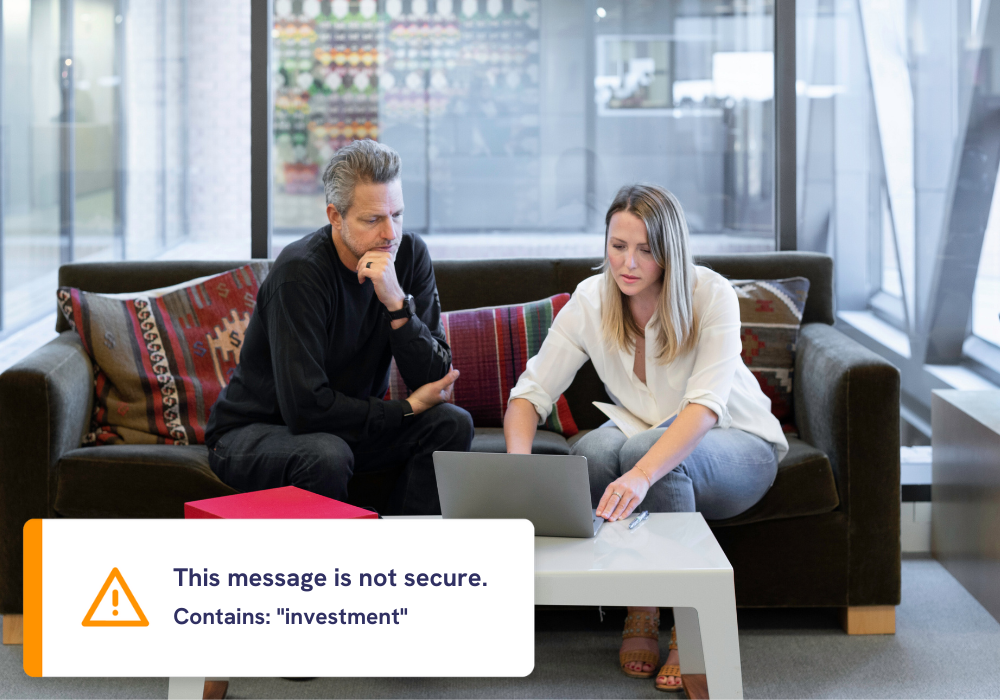 man and woman sitting on office sofa looking at laptop (5)