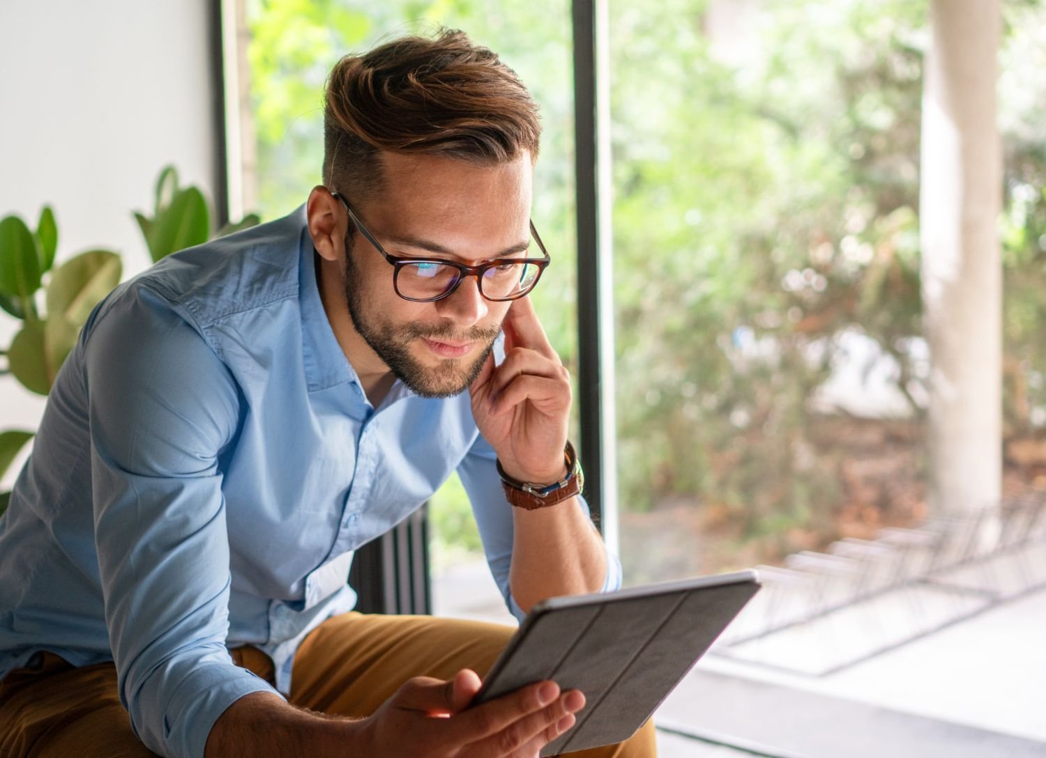 Male professional looking at portal on his tablet