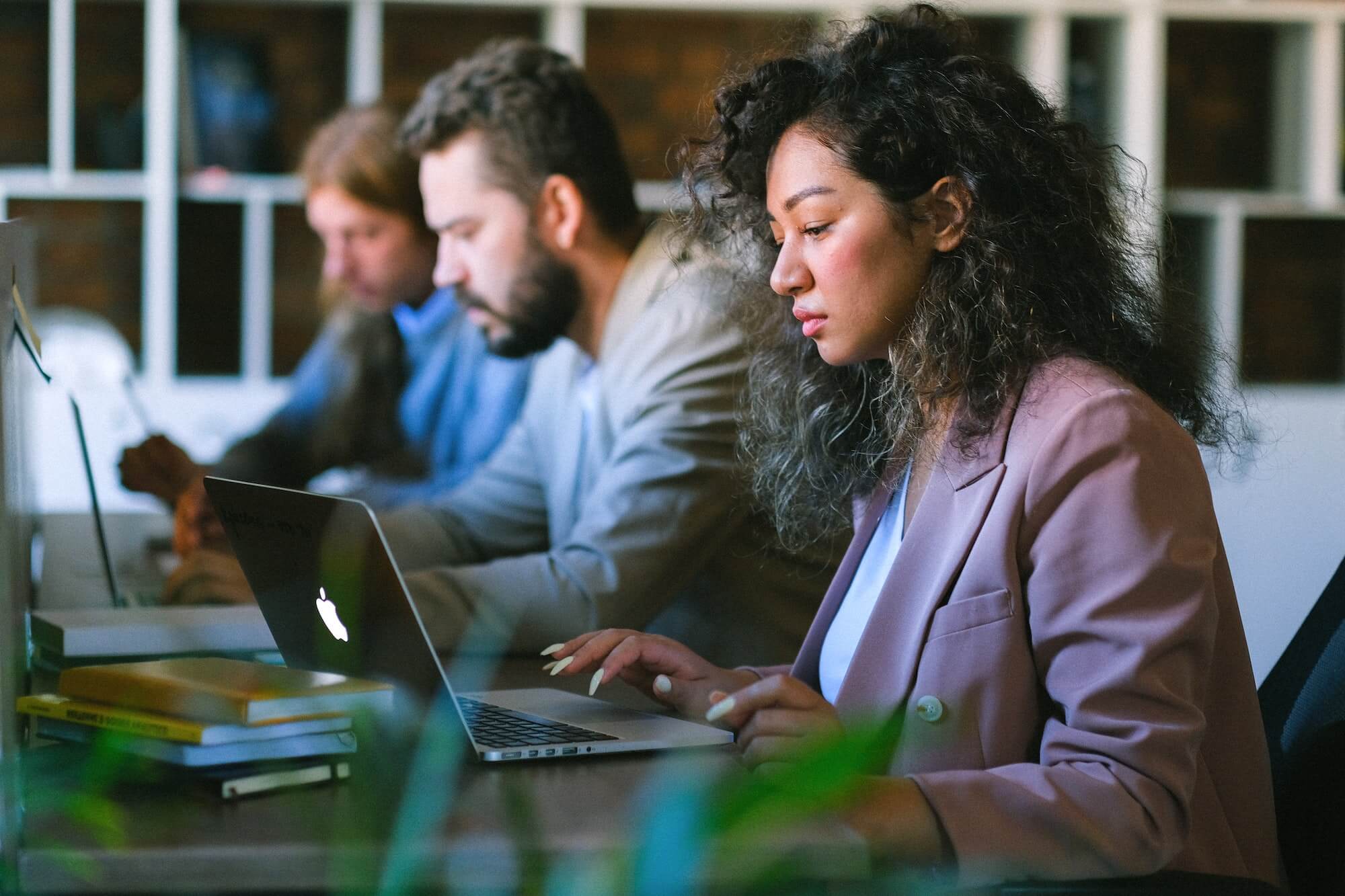 people working at desks using laptops in corporate office