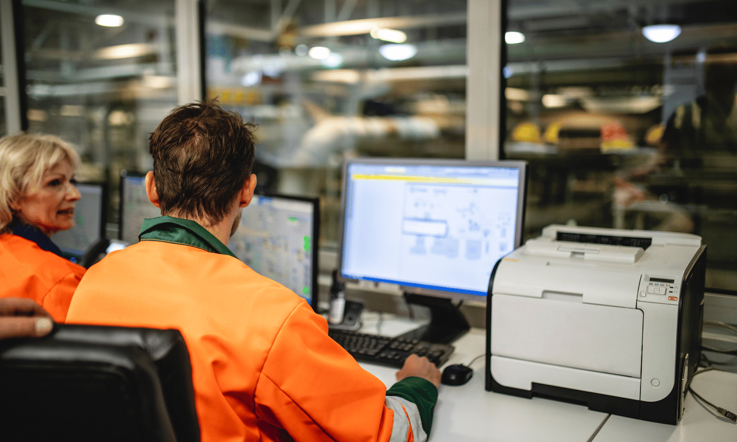 Post facility with workers in front of desktop computer