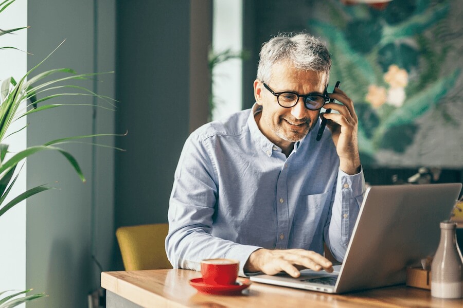 Male professional using Mailock Pro to send a secure email in a canteen using his laptop