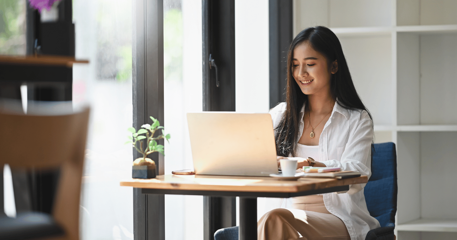 woman in coffee shop using laptop for email