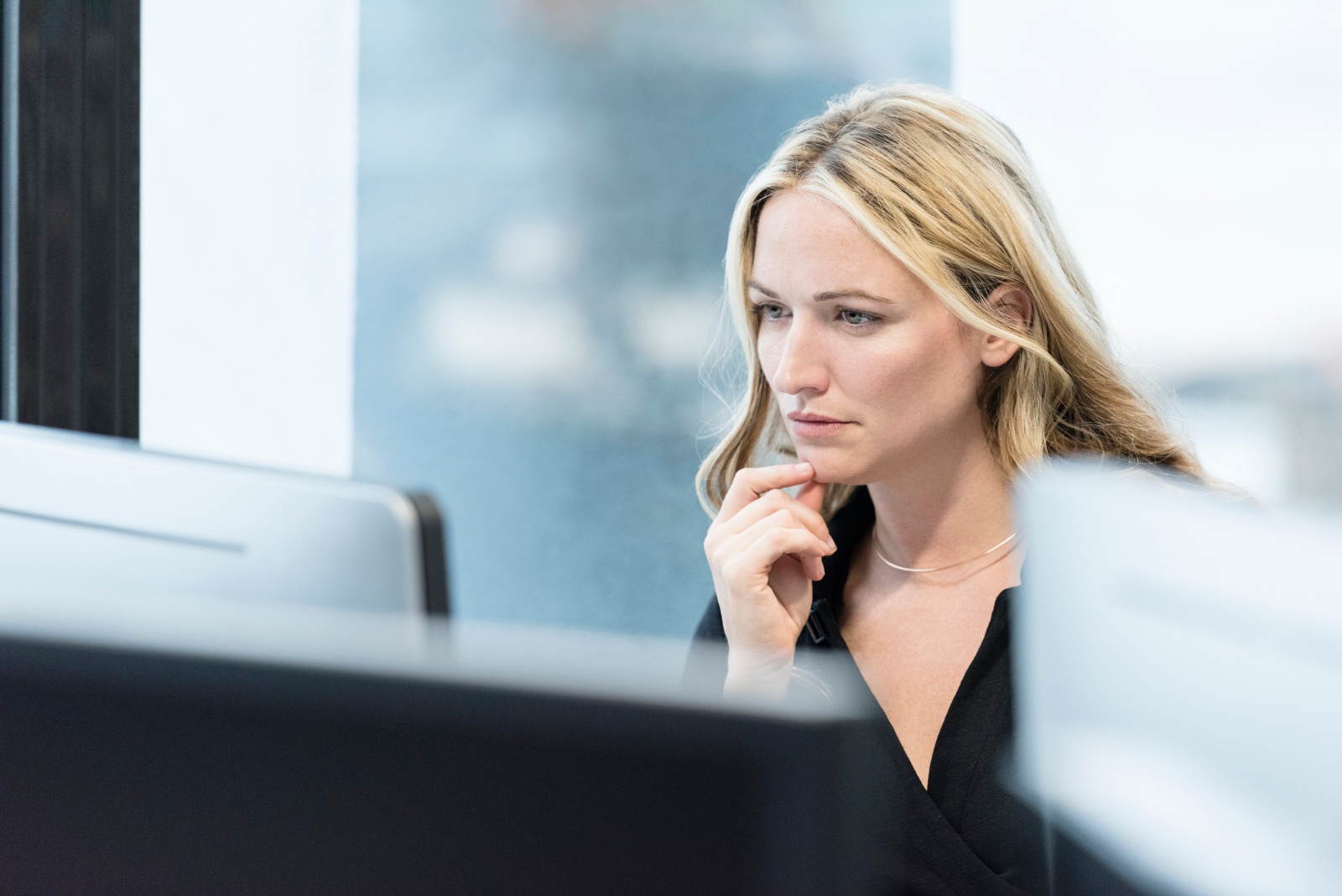 woman looking seriously at desktop computer